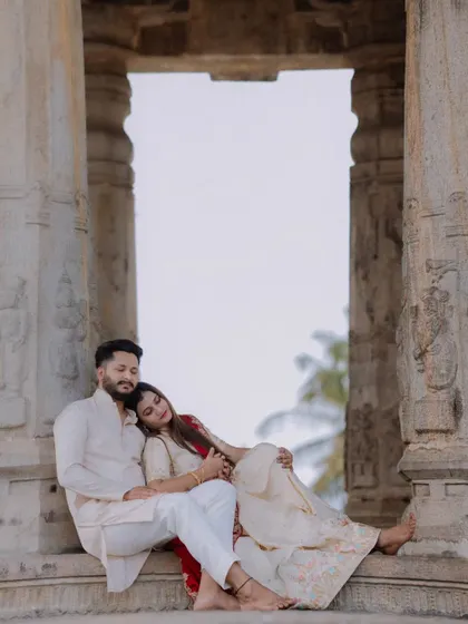 An intimate and tender moment between the couple, framed by the temple's stone pillars. This photo focuses on the emotional connection and quiet anticipation of parenthood.