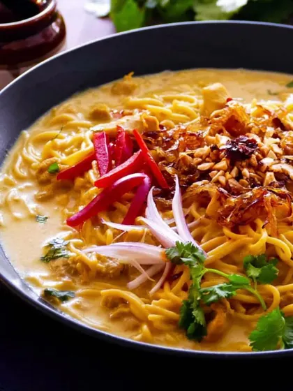 A comforting bowl of Burmese Khowsuey, with rich coconut curry broth, noodles, and an array of crunchy and fresh toppings. This can be served as a main course or in smaller portions as an appetizer.