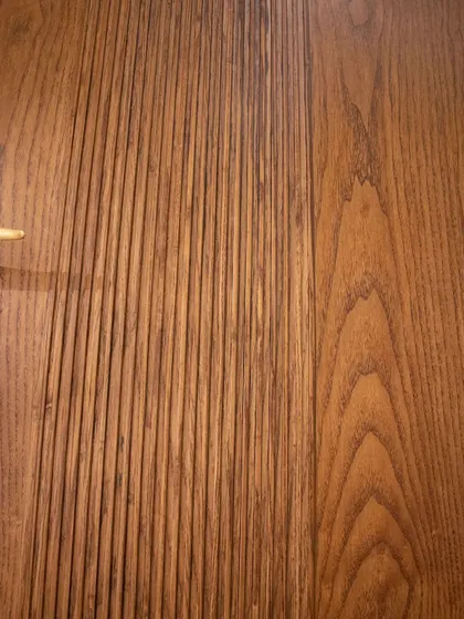A close-up of the fluted texture on the minimalist wooden door, showing the linear grooves that enhance its natural aesthetic.