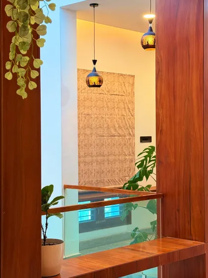 Looking through a wooden partition towards the staircase, this shot highlights our use of layering. The pendant lights and glass railing add to the sense of depth and visual interest.
