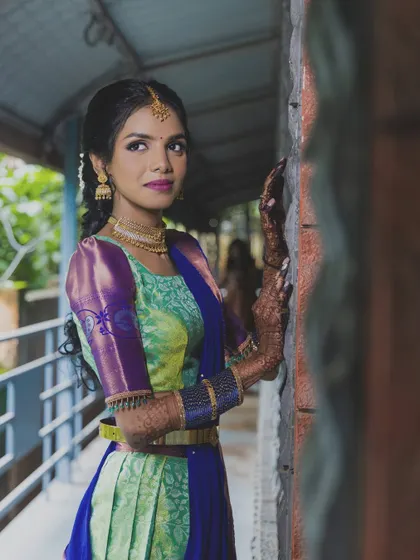 A beautiful half-saree look, perfect for an engagement or pre-wedding event. The makeup features a bold lip to complement the vibrant outfit.