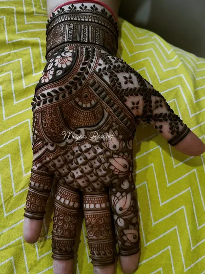 A single hand showing a dense and intricate design, perfect for a bridesmaid or for a sangeet night. It features a mix of floral, paisley, and geometric patterns.
