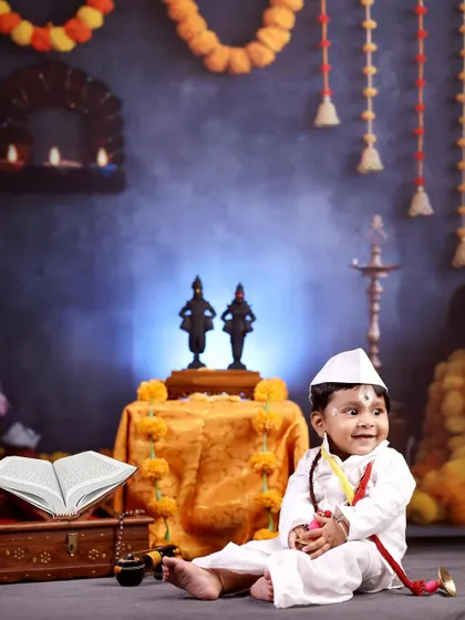 A happy smile from our ten-month-old devotee. The setup with marigold garlands and brass lamps creates an authentic and warm environment for this unique cultural shoot.