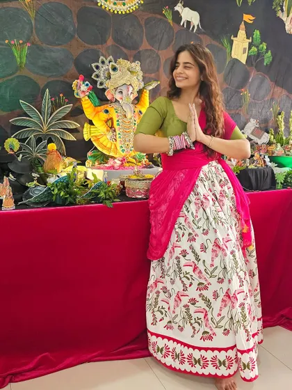 A beautiful moment during Ganesh Chaturthi in a flowy lehenga skirt and a fitted green blouse. The A-line shape of the skirt is perfect for pear shapes, offering comfort without sacrificing style.