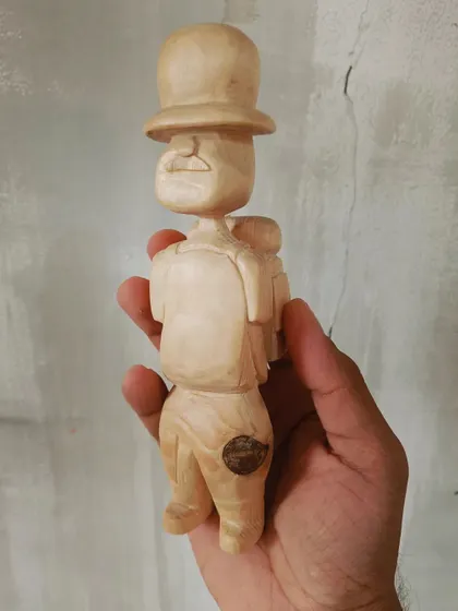 A duplicate of 130, a front view of our little wooden traveler. You can see the details of his mustache and backpack, all hand-carved with care.