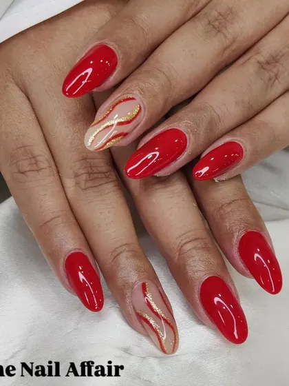 A fiery and elegant design, this set features glossy red nails with accent nails showcasing abstract gold and red swirls on a nude base.
