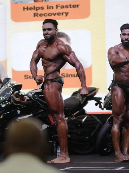 A classic side chest pose, highlighting the chest thickness, shoulder and arm development.