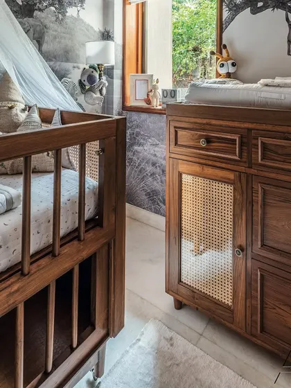 Here you can see the detail on the custom changing table, crafted with drawers and cane-paneled cabinets. It’s designed to be at the perfect height and provide easy access to all the essentials.