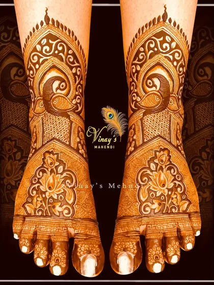 An elegant bridal foot design with peacocks and lotus motifs. The pattern flows beautifully from the ankle to the toes, creating a graceful and elongated look.