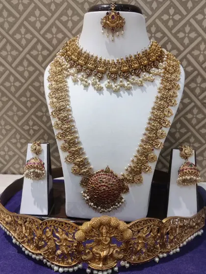 A traditional Kempu bridal set with a large, round pendant, perfect for a classic South Indian wedding.
