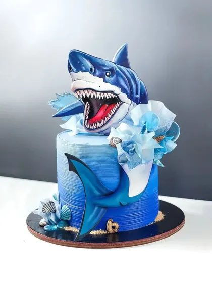 A thrilling shark-themed cake with a 3D shark bursting out of the top. Learn to create realistic water effects and dramatic, sculpted toppers.
