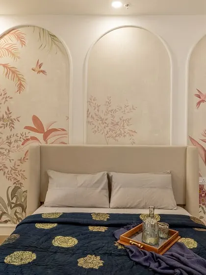An artistic touch for a guest bedroom, featuring a triptych of arched panels with hand-painted botanical murals. This unique headboard design serves as a beautiful focal point for the room.