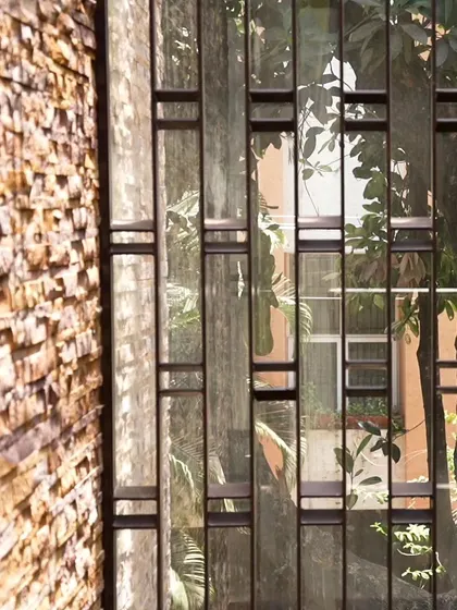 A detailed look at the MS fabricated grill next to the rough texture of the stone cladding. This juxtaposition of smooth, man-made metal and natural, rugged stone is a recurring theme in our work.
