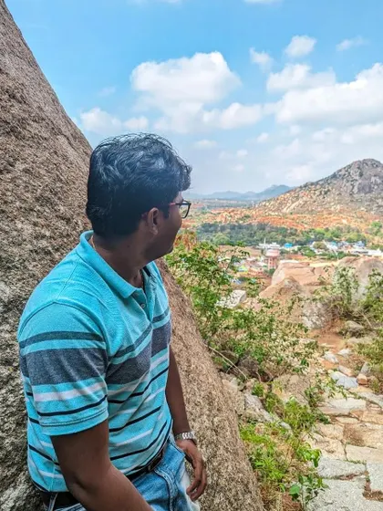 A trekker takes in the scenic beauty of the Gudibande landscape, a perfect escape from the city.