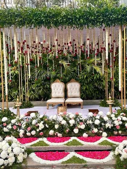 A serene mandap setup with lotus-themed pillars and hanging jasmine garlands, creating a peaceful and spiritual ambiance for the wedding rites.