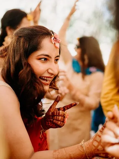 A candid moment of pure joy as the bride dances with her friends during the Haldi ceremony.