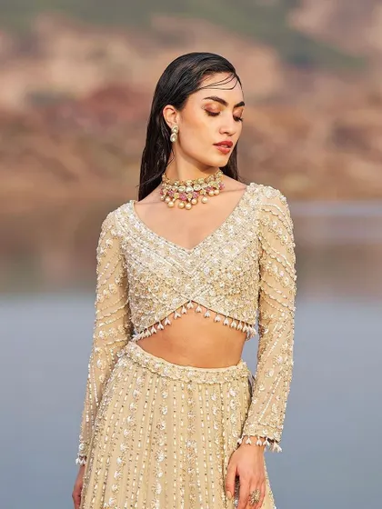 A close-up of the embellished blouse, showcasing the intricate beadwork and flattering neckline.