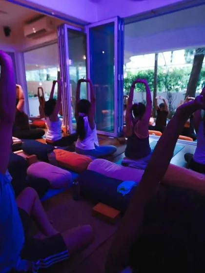 A closer look at the seated stretches under the calming purple and blue lights, showing how we use atmosphere to enhance the mood of the practice.