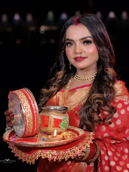 A close-up of the model holding the Karwa Chauth puja thali. This shot focuses on the beautifully decorated thali, the lit diya, and her festive attire.