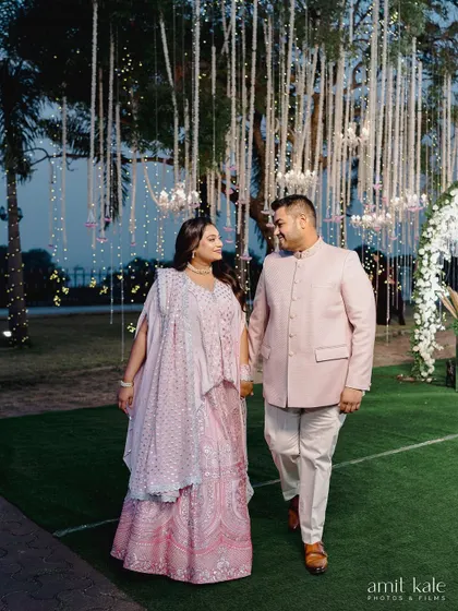 A romantic shot of the couple walking under a beautifully decorated tree at their engagement.