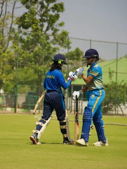 A partnership in action. Two of our female players touch gloves between wickets, showcasing the trust, timing, and teamwork we instill.