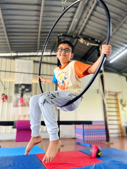 Just hanging out and having fun. This young student enjoys a moment of rest on the aerial hoop, proving that our classes are also about play and enjoyment.