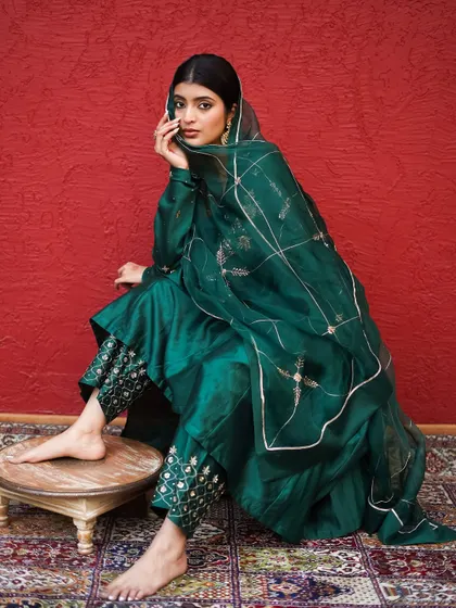 A thoughtful, gentle pose that highlights the delicate details of the outfit and the model's serene expression.