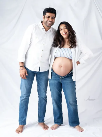 Pure happiness. This fun, casual portrait of an expecting couple in matching white shirts and jeans is full of energy and laughter.