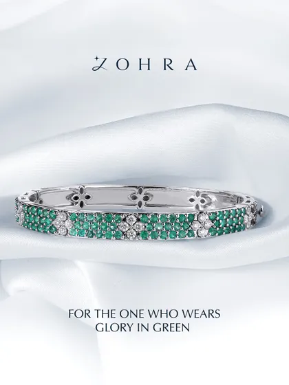 A piece designed to feel like glory in green. This custom bangle is crafted with rows of hand-picked emeralds and brilliant diamonds, set in a floral-patterned white gold band. It's a testament to how we can weave your favourite gems into a design that is both classic and deeply personal.