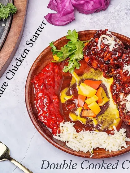 A signature starter, our Double Cooked Chicken is first fried for crispiness and then tossed in a rich, spicy sauce. It's served on a sizzling platter and topped with cheese for a dramatic presentation.