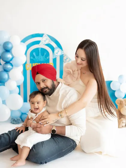 A beautiful family portrait celebrating their son's first birthday. The coordinated outfits and the joyful expressions make this a perfect memory.