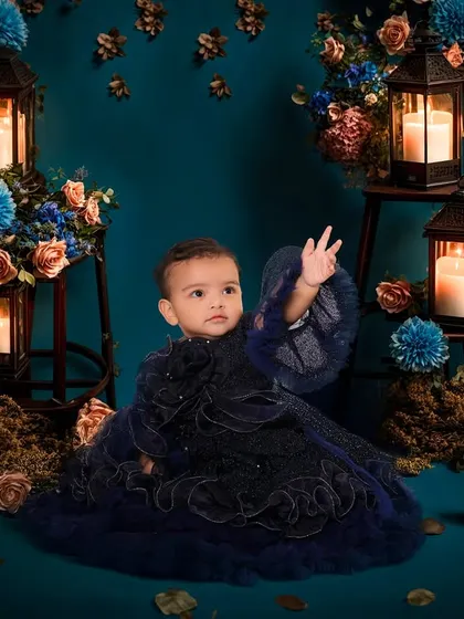 This portrait showcases a more artistic and dramatic style for a sitter session. The deep blue gown and the warm glow from the lanterns create a beautiful, enchanting atmosphere that makes this little one look like she's in a fairytale.