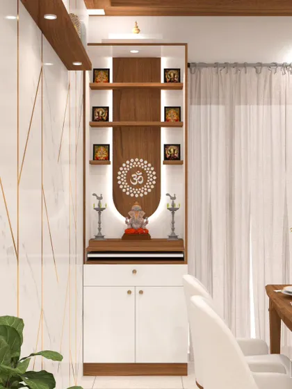 This compact pooja unit is designed to blend seamlessly into a modern dining area. It features a backlit CNC-cut 'Om' motif, multiple illuminated shelves for idols, and a closed cabinet below for storing prayer essentials.