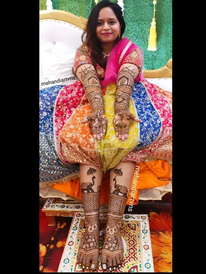A complete bridal look includes beautiful mehandi on the feet as well. Here, you can see how the designs on the hands and feet complement each other, featuring traditional elephant and architectural motifs.
