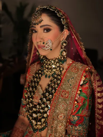 A close-up that captures the intensity and beauty of her bridal makeup. The smokey eye, flawless skin, and traditional nath come together for a powerful and unforgettable look.