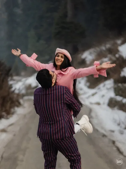 A joyful lift, with arms outstretched, celebrating love in the middle of a snowy paradise. This dynamic shot is full of happiness and freedom, a perfect memory from an adventurous Kashmir pre-wedding session.