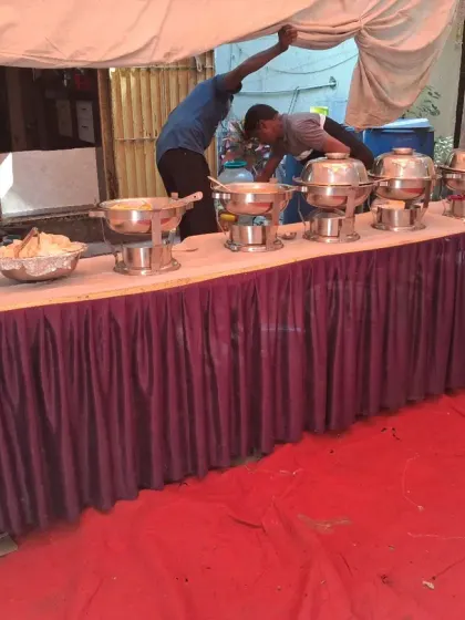 My team setting up the buffet table before an event. I handle everything from setting up the tables to arranging the food, so you don't have to worry.