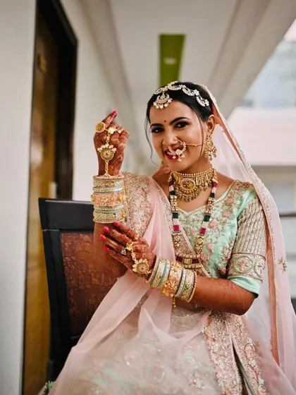 This bride is showcasing her beautiful hand jewellery. The makeup is kept soft and radiant to balance the elaborate details of her look.