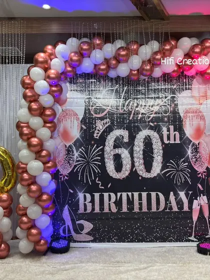 Milestone birthdays deserve a grand celebration. For this 60th birthday, we created an elegant and sophisticated look with a rose gold and white balloon arch, a personalized backdrop, and large foil number balloons to mark the special year.