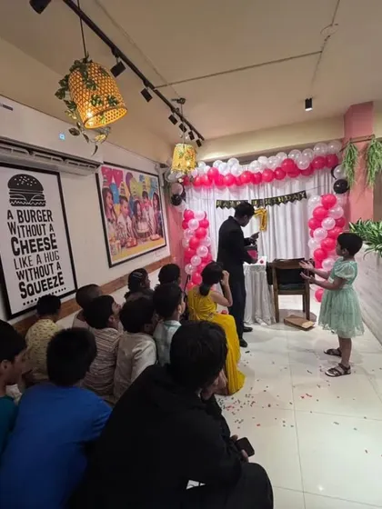 A young audience member helps me with a trick during a lively birthday celebration. I love it when the kids get hands on, as it makes the magic feel real for them.
