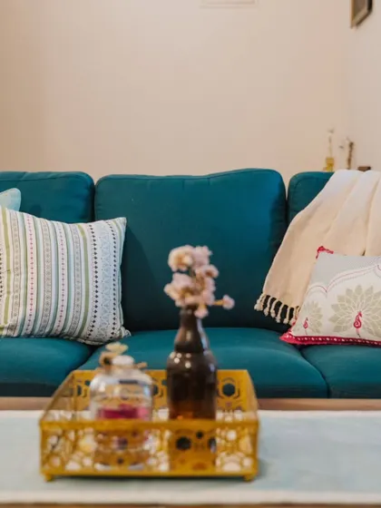 A close-up of a teal sofa styled with our Rani Collection cushions. The mix of patterns and textures adds a festive and vibrant touch to the living space.