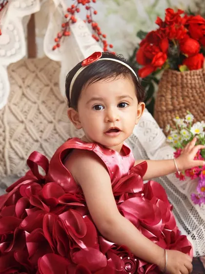 This little girl in her beautiful red dress is exploring the flowers in our boho setup. The colors are so vibrant and joyful.