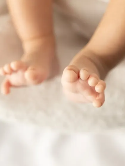 A close-up on a newborn's feet, showing every perfect little wrinkle and toe. These are the details that make your heart melt.