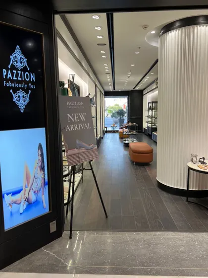 The view from just inside the entrance, showing the flow of the store and the use of digital screens and signage for branding and promotions.