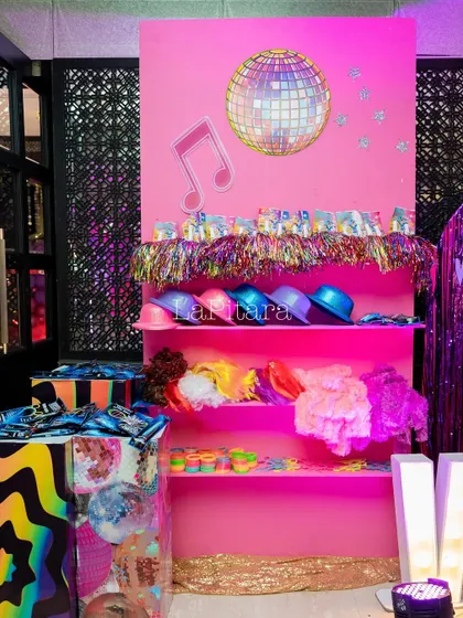 A prop station for the disco party, offering guests colorful wigs, hats, and other fun accessories to get into the theme.