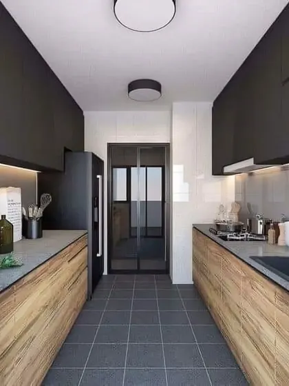 A galley kitchen with a dramatic contrast between dark upper cabinets and wood-grain lower cabinets. The dark floor tiles complete the modern look.