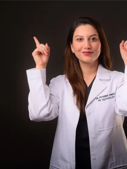 A doctor in her white coat, using a gesture to point upwards. This is a great shot for presentations or social media posts to draw attention to text or a message.