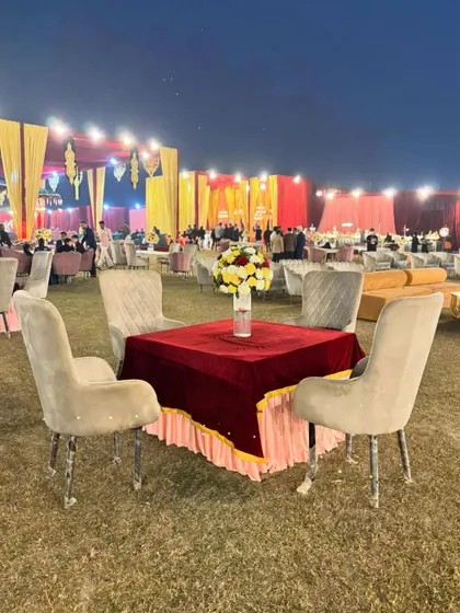 Another perspective of the outdoor seating, showing the vastness of the lawn and the impressive scale of the main tent structure in the background.