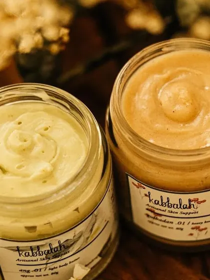 A close-up on the swirled tops of my freshly jarred body butters. This shows the creamy, rich texture that melts into your skin.