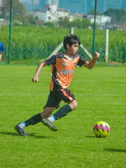 An athlete sprints with the ball, showcasing the speed and agility developed in our youth leagues.
